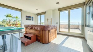 Une salle de bain moderne avec une baignoire en bois, une douche en verre et une vue sur l’extérieur.