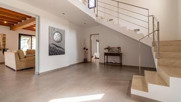A spacious living area with a staircase leading to an upper floor.