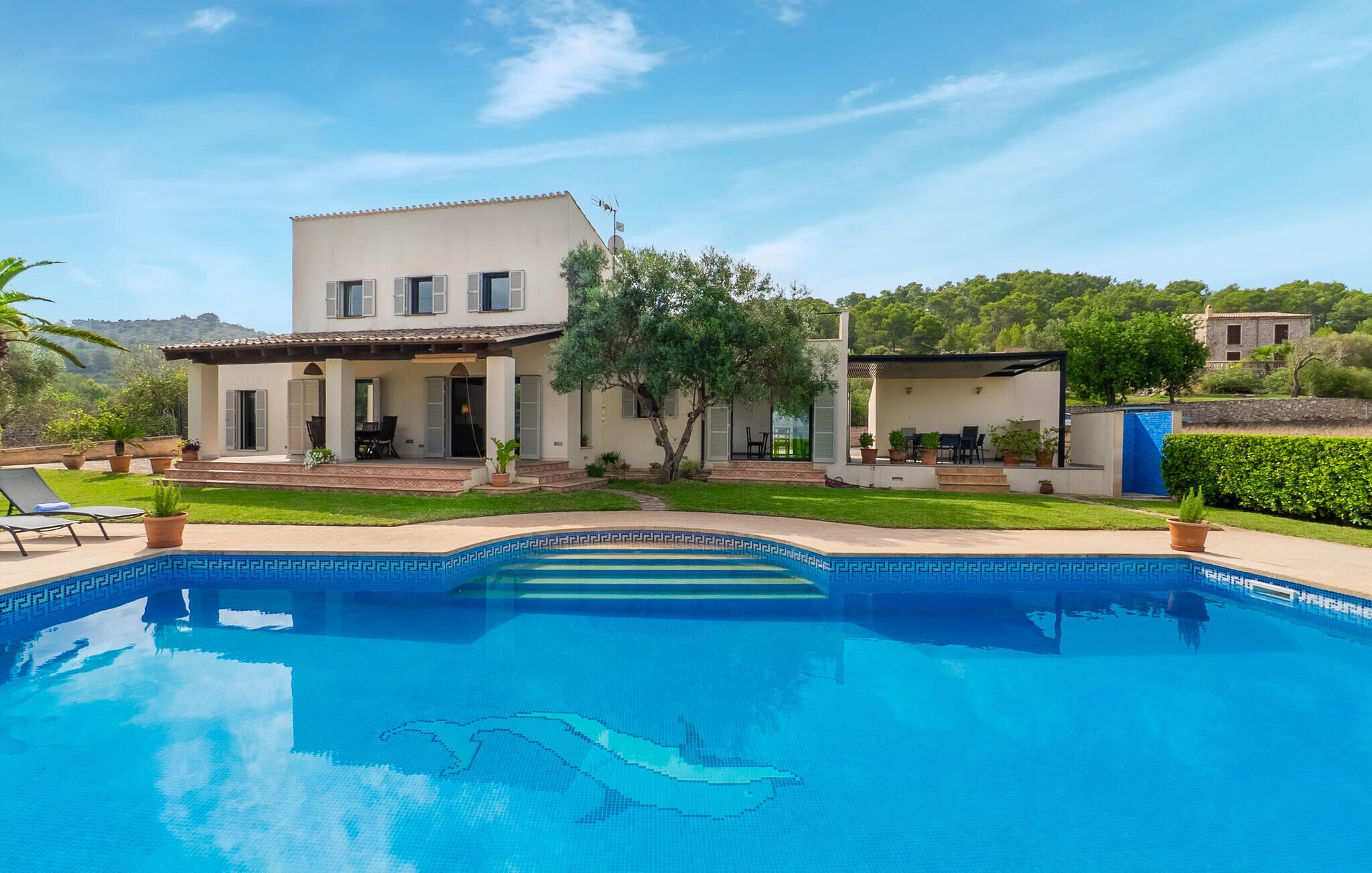 Een moderne villa met een zwembad, terras en tuin.