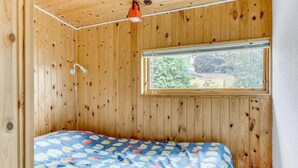 A wooden-paneled room with a bed, a window, and a hanging light fixture. - Lovely home in Haderslev with WiFi (Haderslev)