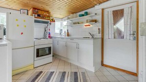 A compact kitchen with white cabinets, a built-in oven, a refrigerator, and a wooden ceiling. - Lovely home in Haderslev with WiFi (Haderslev)