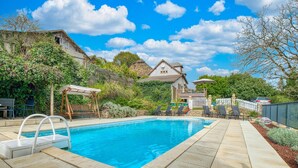 A swimming pool with a pergola and lounge chairs, surrounded by a stone patio and a stone house with a garden. - Awesome home in Beauregard-de-Terrasso (Beauregard-de-Terrasso)