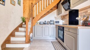 A kitchen with a wooden staircase, white cabinets, and a microwave. - Awesome home in Beauregard-de-Terrasso (Beauregard-de-Terrasso)