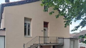 Un bâtiment à deux étages doté d’un balcon, d’un escalier et d’une petite fenêtre.