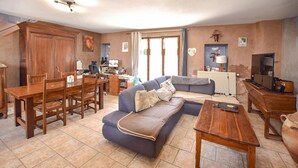 A living room with a sofa, a wooden coffee table, and a dining area with a table and chairs.
