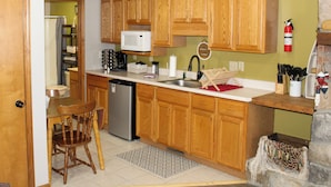 A kitchen with wooden cabinets, a microwave, a sink, and a dishwasher. - Minutes from Giant City - SIU - Shawnee Winetrail - Shawnee Forest - Cedar Lake (Makanda)
