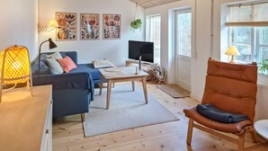 A living room with a sofa, a table, a chair, a TV, and artwork on the wall. - Beautiful home in ærøskøbing with WiFi (Ærøskøbing)