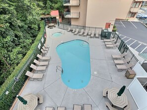 Un espace piscine aménagé sur le toit, avec des chaises longues et une piscine.