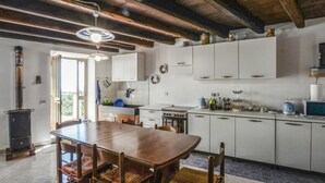 A kitchen with white cabinets, a wooden dining table, and a stove.