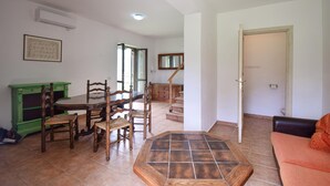 A dining area with a wooden table and chairs, a green cabinet, and a tiled floor. - 3 bedroom stunning home in Vignanello (Vignanello)