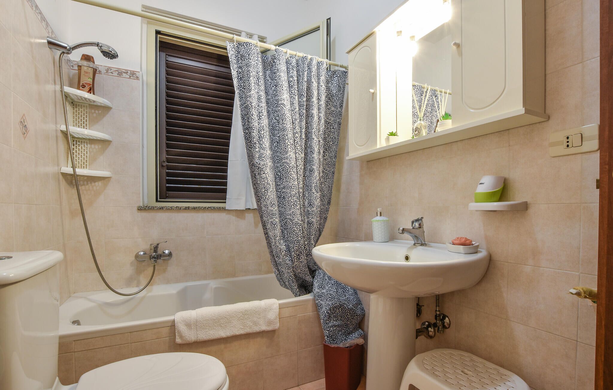 A bathroom with a bathtub, toilet, and sink.