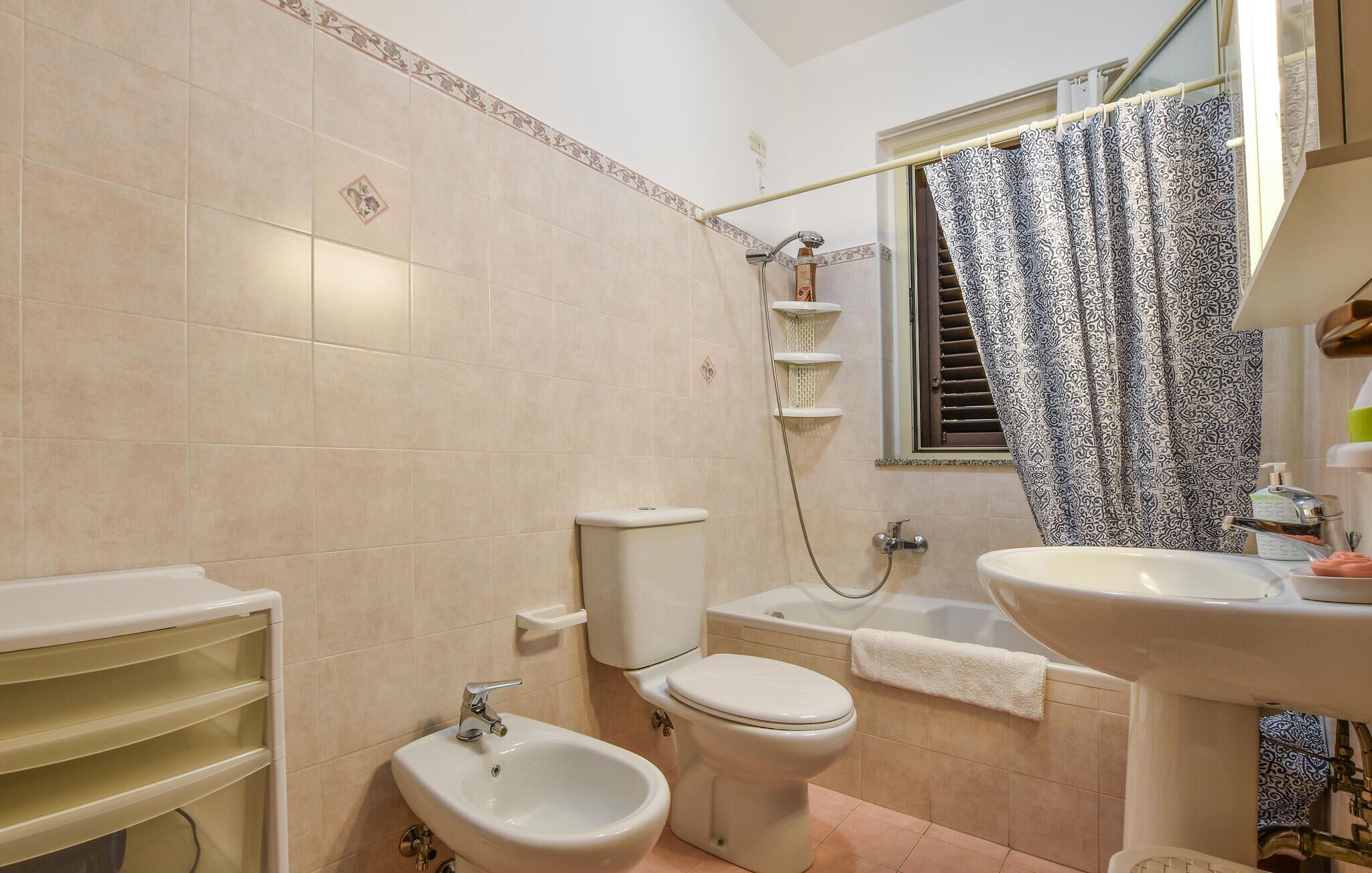 Une salle de bain comprenant des toilettes, un bidet, une baignoire et un lavabo.
