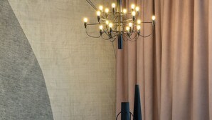Un espace de salle à manger moderne avec une table ronde, des chaises noires et un lustre.