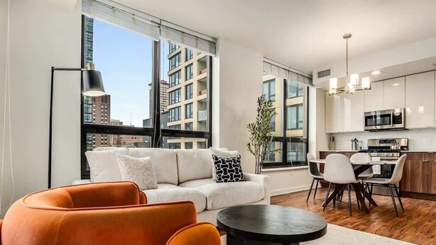 A modern apartment with a living room, dining area, and kitchen. - Boulevard Stays - River North (Chicago)