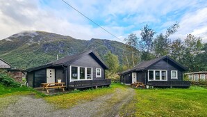 Two cabins with wooden decks and large windows, set against a backdrop of mountains and a clear sky. - Awesome home in Røldal with WiFi (Røldal)