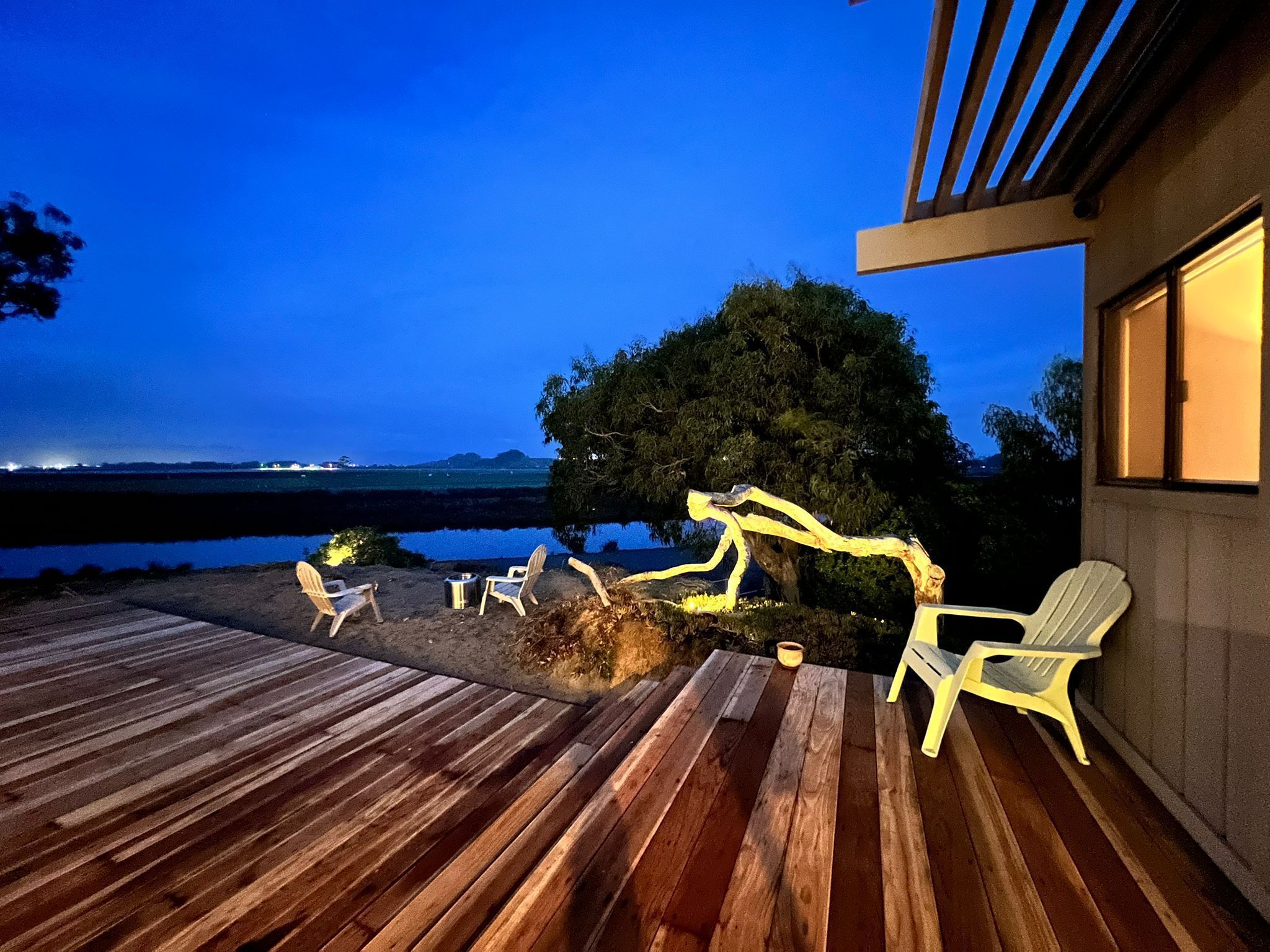 A wooden deck with outdoor seating and a view of the water.