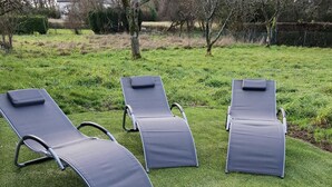 Three outdoor lounge chairs on a well-maintained lawn with a hedge and trees in the background. - GITE DE L'ETOILE - ROCROI (ROCROI)
