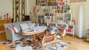 A cozy living room with a grey sofa, a round coffee table, and a bookshelf filled with books. - Stunning home in Höllviken with WiFi (Höllviken)