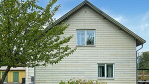 Een gelijkvloers huis met een puntgevel, een voordeur en een klein voortuintje.