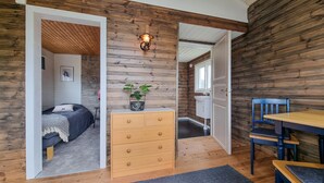 Een gezellige kamer met een bed, een dressoir, een bureau en een stoel.