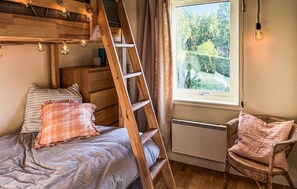 A bedroom with a bunk bed, a ladder, a chair, and a window with a view of greenery. - Pet friendly home in Vätö with sauna (Vätö)
