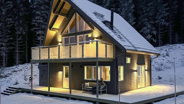A modern, two-story cabin with a balcony, surrounded by snow-covered trees. - Amazing home in Sysslebäck with sauna (Sysslebäck)