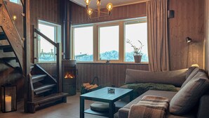A cozy living room with a fireplace, a sofa, a coffee table, and a staircase. - Amazing home in Sysslebäck with sauna (Sysslebäck)