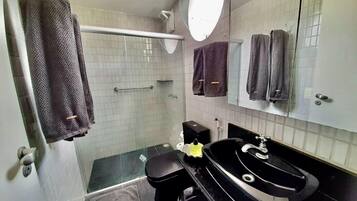 A bathroom with a shower, toilet, and sink.