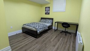 Une chambre à coucher avec un lit, un bureau et une chaise.