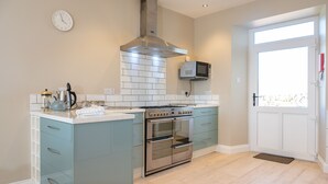 A modern kitchen with a built-in oven, microwave, and stainless steel range hood.