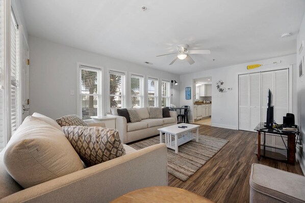 A modern living room with a sofa, coffee table, and a ceiling fan.