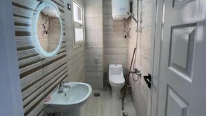 Un baño estrecho con lavabo, espejo, inodoro y calentador de agua.