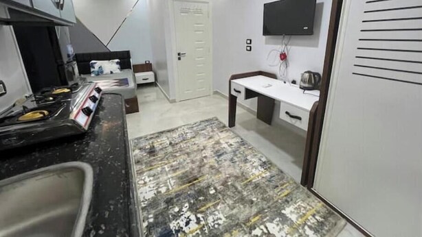 Una cocina moderna con estufa a gas, un lavamanos y una zona de comedor con mesa y sillas.