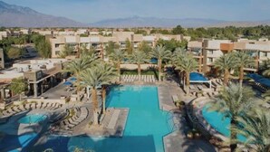 A resort with multiple swimming pools, palm trees, and a mountainous backdrop. - Coachella Perfect! Cozy studio, sleeps 4 in Palm Desert with fitness room, AC.  (Palm Desert)