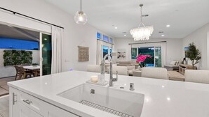 A modern kitchen with a large island, stainless steel appliances, and pendant lighting. - Harlow House - Lounge poolside in Indian Wells (Indian Wells)