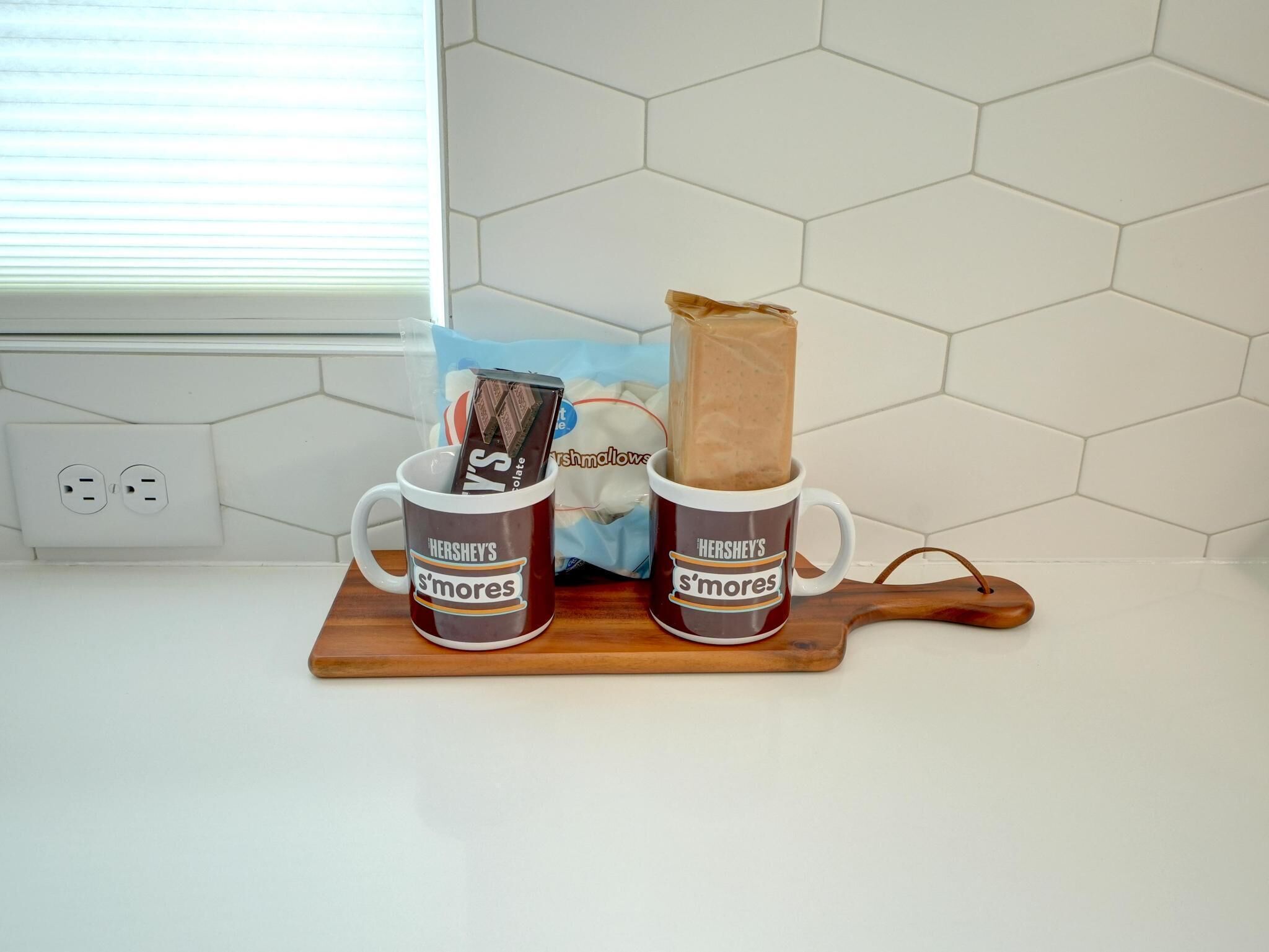 Dues tasses amb la marca Hershey's de s'mores sobre un tauler de fusta.