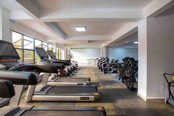 A gym with treadmills, stationary bikes, and exercise equipment.