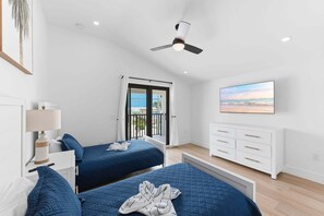 A hotel room with two beds, a ceiling fan, a TV, and a balcony with a view. - Walk To Beach, North End Restaurants, Night Life Steps Away! (Fort Myers Beach)