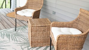 Two wicker chairs with white cushions on a porch with a palm leaf patterned rug. - Charming guest suite only 3 miles from Sight & Sound Theater. (Smoketown)