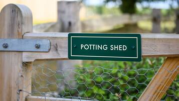 Ein hölzernes Tor mit einem Schild, auf dem 'POTTING SHED' steht.