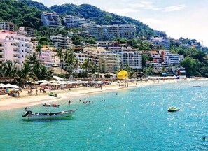 Eine Küstenstadt mit Strand, Booten und Gebäuden.