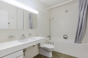 Ein modernes Badezimmer mit Waschbecken, Spiegel, Toilette und Dusche.