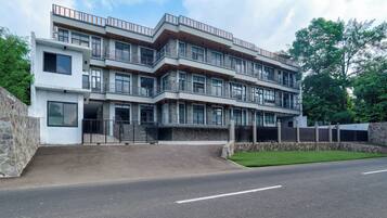 A multi-story residential building with a modern architectural design, featuring balconies and large windows.