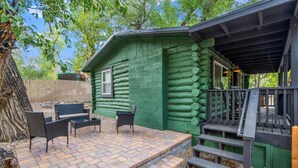 A log cabin with a patio area featuring outdoor furniture and a wooden deck. - The Prescott Granite Dell's Getaway! (Prescott)