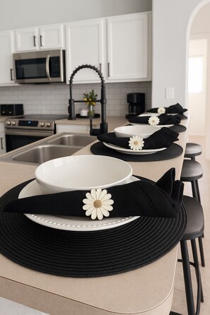 A kitchen with white cabinets, a microwave, and a coffee maker.