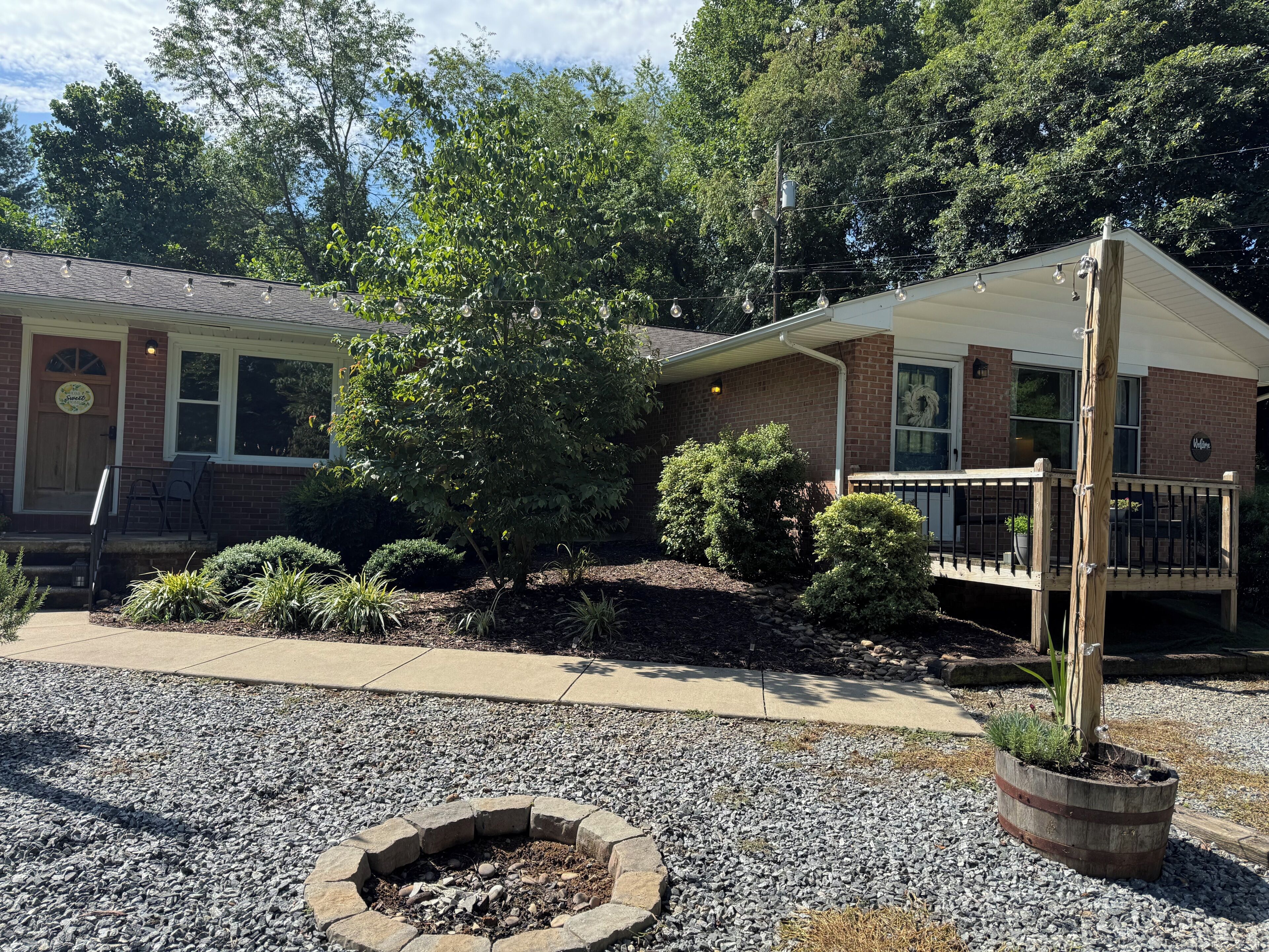 A building with a brick facade, a covered porch, and a fire pit area.