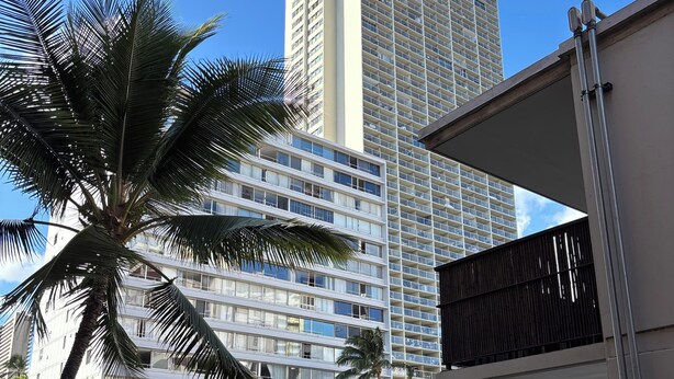 A multi-story building with a modern architectural design, featuring balconies and large windows. - Relax in Style: Waikīkī Condo w/ Lanai (Honolulu)