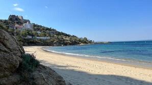 A beach with a rocky cliff, a building on a hill, and calm sea. - 2222 - MEDITERRANEO A 1-8, HOLIDAYS ON THE ROCKS, 1st LINE OF SEA, PRIVILEGED AREA, SEA VIEW. (Roses)
