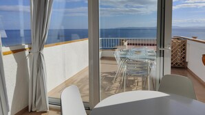 A balcony with a glass table and chairs, overlooking a coastal view. - 2222 - MEDITERRANEO A 1-8, HOLIDAYS ON THE ROCKS, 1st LINE OF SEA, PRIVILEGED AREA, SEA VIEW. (Roses)
