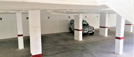 Un aparcamiento con plazas numeradas y un coche estacionado en la plaza número 17.
